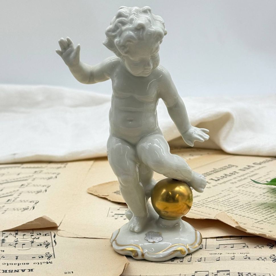 Статуэтка Schaubach Kunst Путти с шаром 17 см фарфор Германия до 1953 г.
