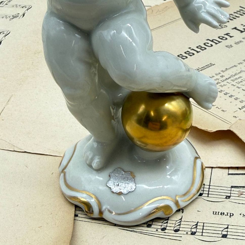 Статуэтка Schaubach Kunst Путти с шаром 17 см фарфор Германия до 1953 г.